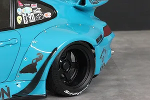 Close-up of the rear quarter section of a bright blue RWB 993 RC body shell featuring wide fender flares and a black wheel.