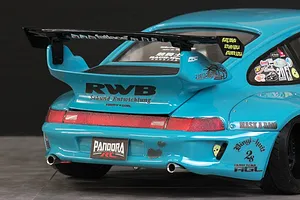 Close-up of the rear end of a light blue RWB 993 type RC body shell featuring a large black wing, RWB decals, and dual exhaust tips.
