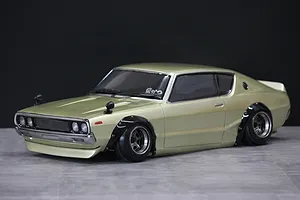 Painted light gold Nissan Skyline 2000GT-R Kenmeri RC body shell on a studio table.
