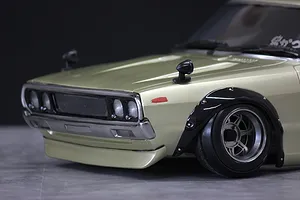 Close-up of the front quarter and fender of a metallic gold KPGC110 Skyline 2000GT-R RC car body shell.