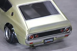 Rear corner view of a gold Pandora RC KPGC110 Skyline 2000GT-R body shell showing tail lights, exhaust, and fender flares.