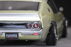 Close-up rear angle of Pandora RC KPGC110 Skyline 2000GT-R drift body shell in pale gold with black fender flares.