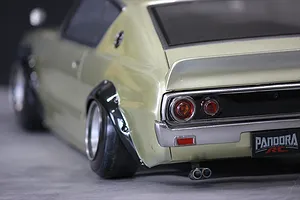 Close-up rear angle of a light green Pandora RC KPGC110 Skyline 2000GT-R drift car body shell showing wheels, tail lights, and exhaust.