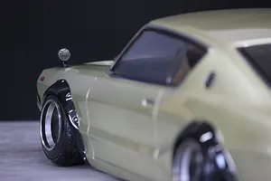 Close-up of the front fender, wheel, and side mirror of a light green Pandora RC Skyline 2000GT-R drift car body shell.