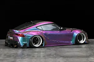 Rear-three-quarter studio shot of a Pandora RC Toyota GR Supra RC drift body shell with a color-shifting purple and blue paint finish on a dark surface.