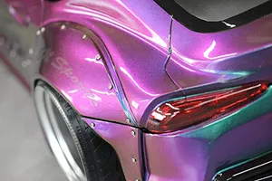 Close-up detail shot of the rear quarter panel and fender flare on a metallic purple and green colour-shifting RC drift car body.
