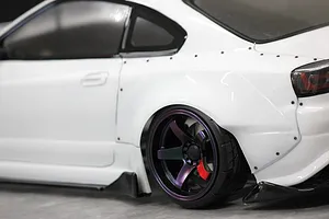 Close-up of the rear quarter section and wheel of a white RC drift car body with a wide body kit.