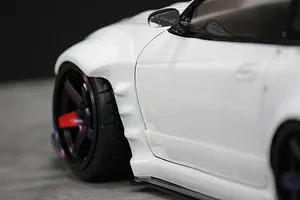 Close-up of the front fender and wheel on a white RC drift car body.