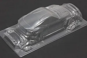 Unpainted clear polycarbonate RC drift car body shell viewed from the rear three-quarter angle against a dark background.