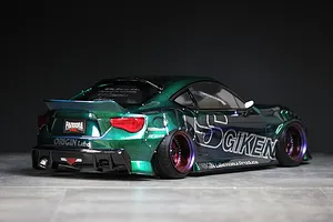 Rear three-quarter view of a metallic green RC drift car body shell styled as a Toyota 86 with custom decals and deep dish wheels.