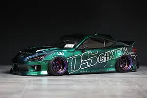 Custom green metallic RC drift car body shell mounted on a chassis with purple and black deep dish wheels and OS Giken sponsor decals.