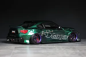 Custom painted green RC drift car body modeled after a Toyota 86 with Origin Labo decals, shown on a grey surface.