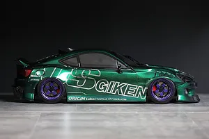 Side profile of a custom painted metallic green RC drift car body on a grey surface and dark background.