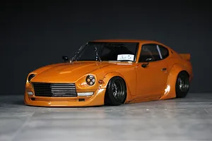 An orange painted RC drift car body styled as a classic Datsun Fairlady Z S30 with wide body fenders and deep dish wheels.