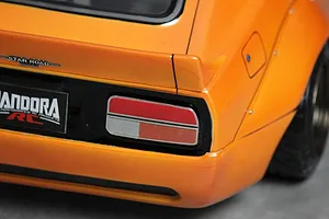 Close-up of the rear corner of an orange Pandora RC S30 Fairlady Z body shell featuring a Star Road badge and detailed tail light.