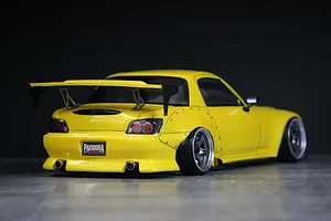 Rear view of a yellow Honda S2000 RC drift car body shell featuring a large wing, wide fender flares, and Pandora RC license plate.