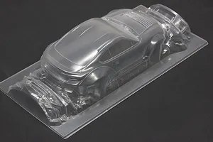 Unpainted clear polycarbonate RC car body shell on a dark background showing rear three-quarter view.