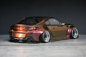 Rear three-quarter view of a custom painted RC drift car body styled as a Toyota GR86 with wide fenders and deep dish wheels.