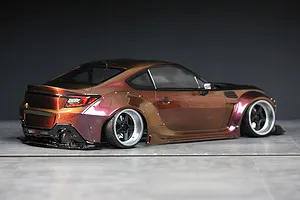 Custom painted RC drift car body styled as a Toyota GR86 with wide body kit in a gradient brown and magenta metallic color.