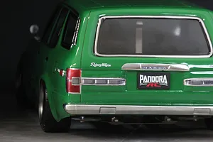 Close-up rear view of a green RC car body shell showing tail lights, chrome bumper, and Pandora RC license plate.