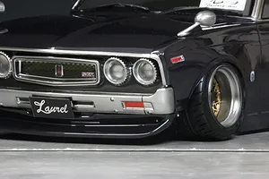 Close-up of the front end of a custom dark-painted Pandora RC C130 Laurel drift body shell on a grey surface.