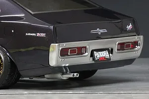 Close-up rear angle of Pandora RC C130 Laurel body shell in dark metallic paint with chrome bumper, dual exhaust, and Pandora RC license plate.
