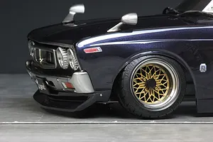 Close-up front quarter view of the dark blue Pandora RC C130 Laurel body shell showing fender mirrors and gold mesh wheels.