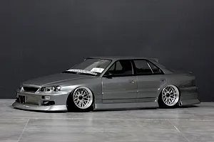 Side-profile view of a grey Pandora RC Nissan ER34 Skyline 4-door drift body shell fitted with custom silver mesh wheels.