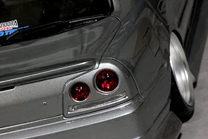 Close-up detail shot of a grey RC car body shell showing the rear taillight and wheel camber.