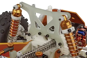 Close-up studio shot of the rear suspension and chain drive mechanism of a Team Associated RC10 RC buggy.