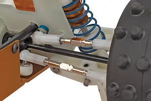 Close-up studio view of the RC car suspension, turnbuckles, and spiked rubber tyre against a plain white background.