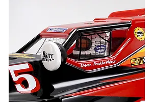 Close-up of the cockpit and driver figure on a red and black Tamiya RC buggy body with decals.