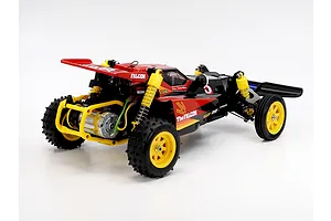 Rear-three-quarter studio view of the Tamiya The Falcon 2026 RC buggy, showing its red and black body, yellow wheels, and rear motor.