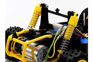 Close-up view of the rear suspension, yellow shocks, motor, and chassis of the Tamiya The Falcon 2026 RC buggy.
