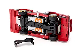 Underside view of the Kyosho First Mini-Z 1982 Nissan Super Silhouette RC car showing inserted batteries and battery cover.