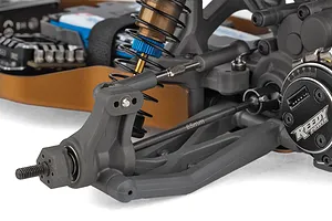 Close-up view of the rear suspension, a-arm, threaded shock absorber, and Reedy Power motor on a 1/10 scale RC car.