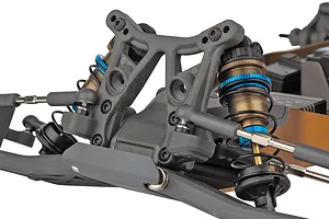 Close-up view of the rear suspension, shock towers, and threaded oil-filled shocks on an RC buggy chassis.