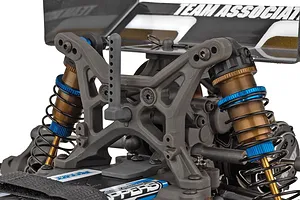 Close-up view of the rear suspension, shock towers, and shock absorbers on a Team Associated 1/10 scale RC buggy.