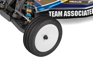 Close up of front wheel, suspension, and body panel of Team Associated RC buggy on a white background