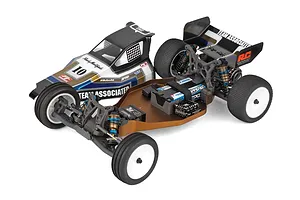 Team Associated 1/10 scale 2WD RC buggy chassis with bronze anodized aluminium deck, electronics, and black, blue, and silver retro-styled body shell.