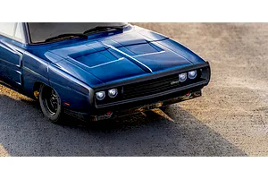 Close-up lifestyle shot of the front section of the blue Kyosho 1970 Dodge Charger RC car on asphalt.