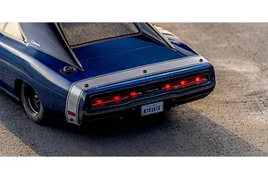 Rear close-up view of the blue Kyosho 1970 Dodge Charger RC car showing illuminated taillights, rear stripe, and California license plate.