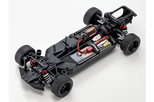 Top down studio view of the black composite chassis for the Kyosho Fazer MK2 RC car, featuring installed motor, battery, and suspension.