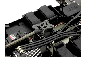Close-up of a Kyosho RC car chassis interior featuring a carbon fibre top plate installed over the centre diff mount.