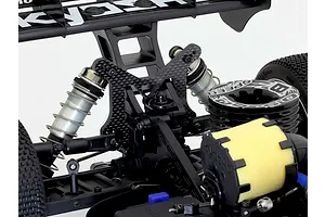 Kyosho carbon fibre rear shock tower installed on the rear of an RC buggy chassis, showing suspension and shock absorbers.