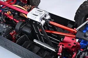 Close-up of a silver aluminium and carbon fibre centre tower brace installed in an RC car chassis.