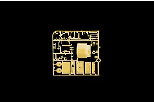 Tan plastic model kit sprue containing various parts and panels for military vehicle assembly against a black background.