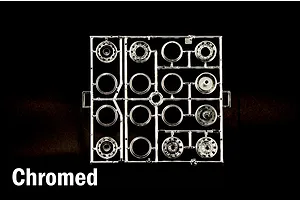 Chrome plated plastic model kit parts sprue containing wheels and rims on a black background.