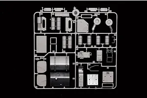 Grey plastic model kit sprue containing various truck parts such as fuel tanks, steps, and air filters against a black background.