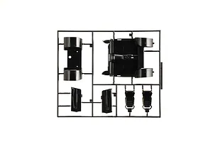 Black plastic model kit sprue containing interior car parts such as seats, floor pan, and door panels.